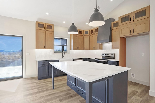 kitchen with stainless steel electric range oven, decorative light fixtures, a center island, light stone counters, and wall chimney exhaust hood