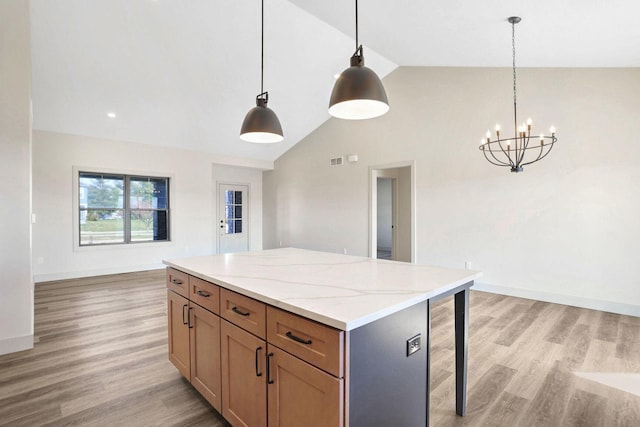 kitchen with lofted ceiling, a center island, light wood-type flooring, and decorative light fixtures