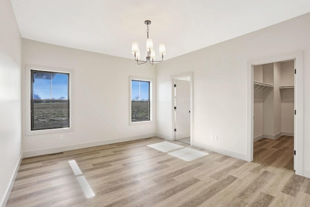 interior space with light hardwood / wood-style floors and a notable chandelier