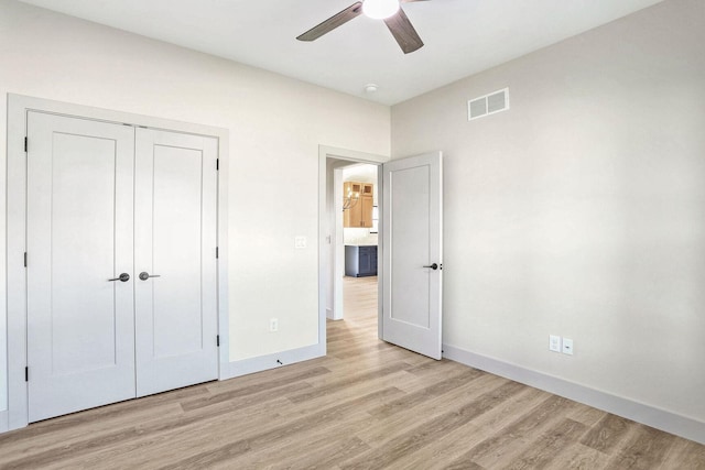 unfurnished bedroom with ceiling fan, light hardwood / wood-style floors, and a closet