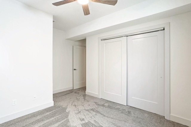 unfurnished bedroom featuring light carpet, a closet, and ceiling fan