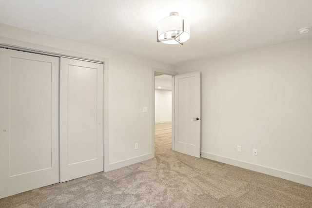 unfurnished bedroom featuring light carpet and a closet