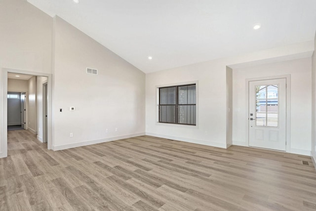 foyer featuring high vaulted ceiling and light hardwood / wood-style floors