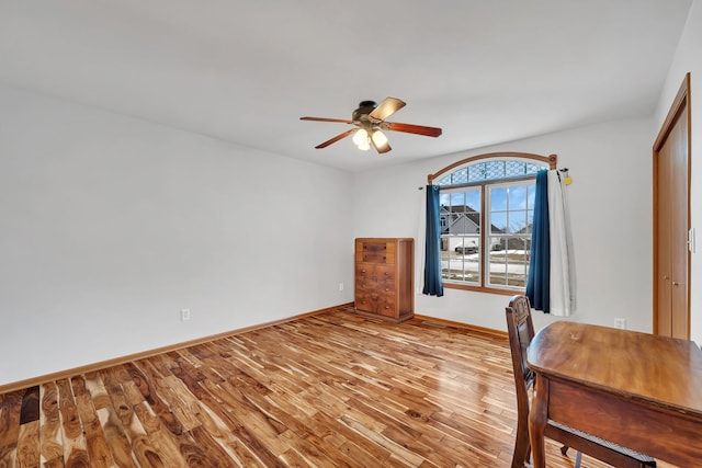 unfurnished office with ceiling fan and light wood-type flooring