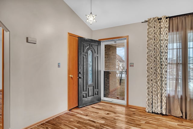 entrance foyer with vaulted ceiling and light wood-type flooring