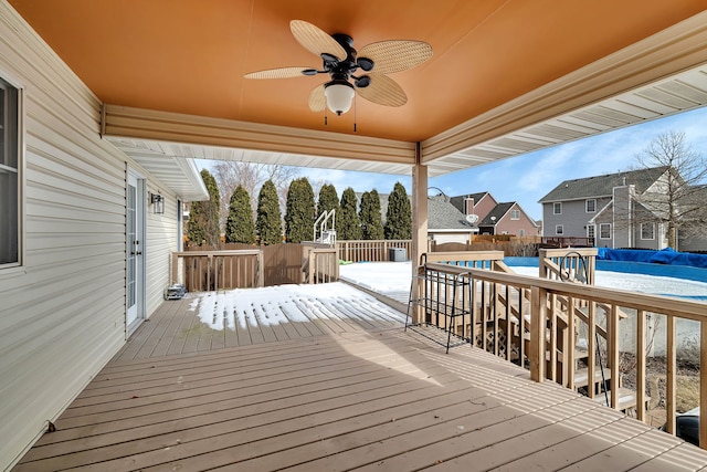 wooden deck with ceiling fan and a covered pool