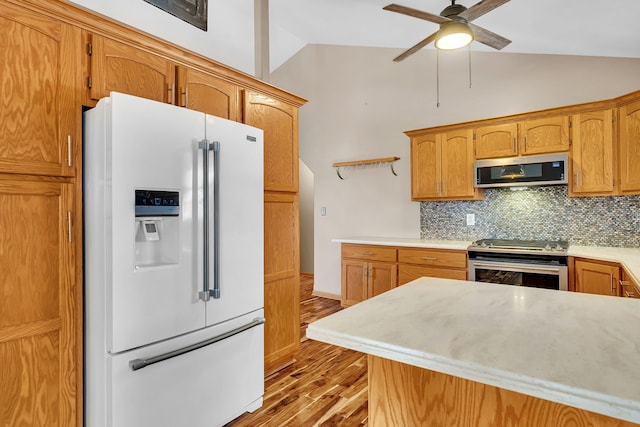 kitchen featuring lofted ceiling, ceiling fan, appliances with stainless steel finishes, tasteful backsplash, and light wood-type flooring