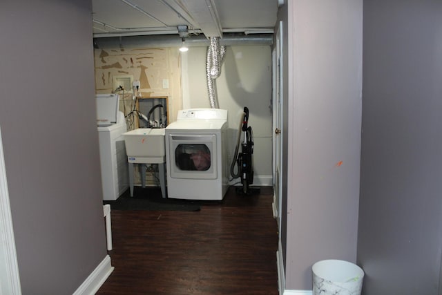 clothes washing area with sink, dark hardwood / wood-style floors, and washer and dryer