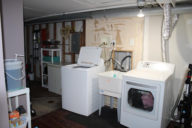 clothes washing area featuring washing machine and clothes dryer, electric panel, and sink