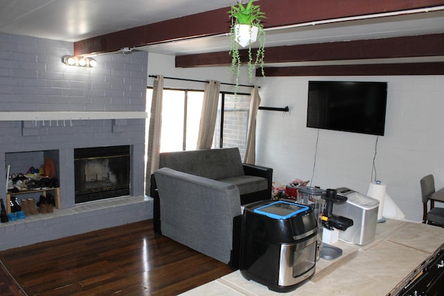 living room featuring a brick fireplace, beam ceiling, and dark wood-type flooring