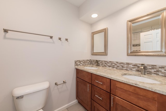 bathroom featuring tasteful backsplash, vanity, tile patterned flooring, and toilet