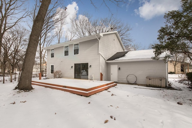 snow covered rear of property featuring a deck