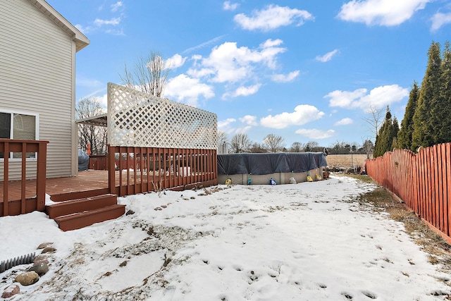 yard layered in snow with a swimming pool side deck