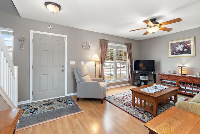 living room with ceiling fan and light hardwood / wood-style flooring