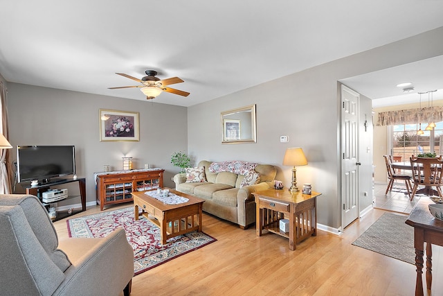 living room featuring ceiling fan and light hardwood / wood-style flooring