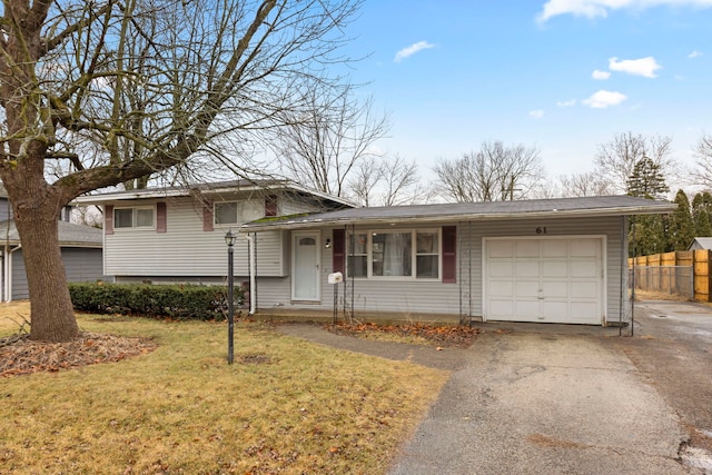 tri-level home featuring a garage and a front lawn