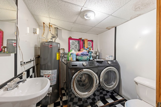 laundry area featuring gas water heater, sink, and washing machine and dryer