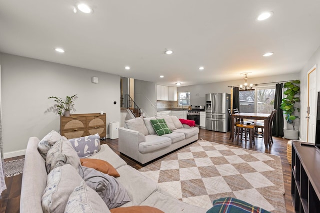 living room featuring a notable chandelier, light wood-type flooring, and a wealth of natural light