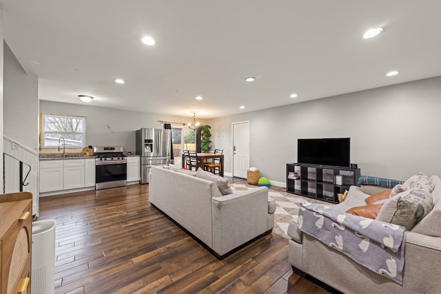 living room with dark wood-type flooring, sink, and a notable chandelier