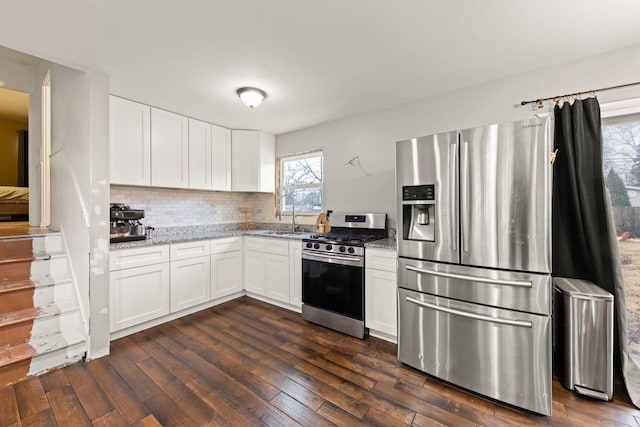 kitchen with white cabinetry, sink, light stone countertops, and appliances with stainless steel finishes