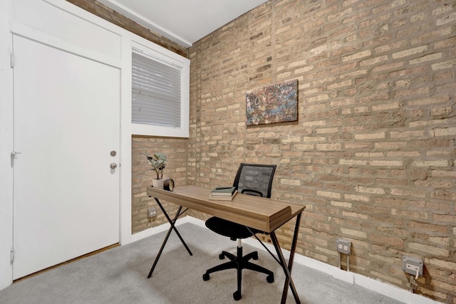 home office with light colored carpet and brick wall