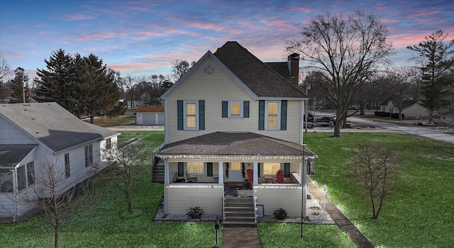 view of front of home with covered porch and a lawn