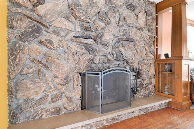 interior details with a stone fireplace and hardwood / wood-style floors