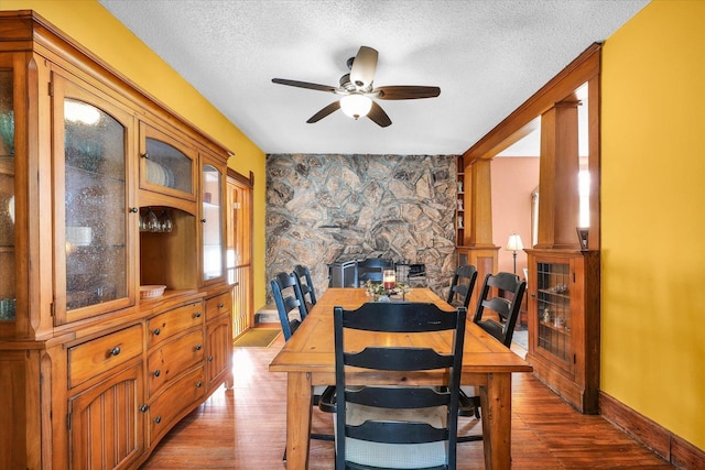 dining area with hardwood / wood-style flooring, ceiling fan, and a textured ceiling