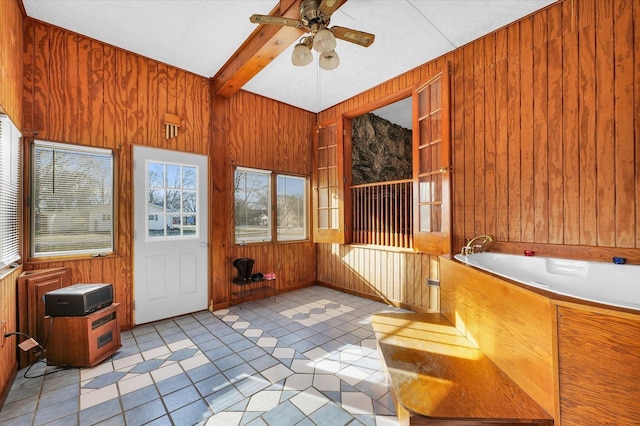 unfurnished sunroom with ceiling fan and beamed ceiling