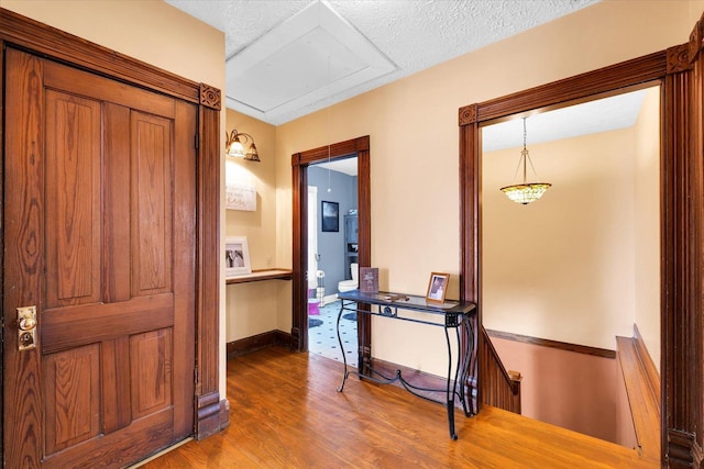 hallway with wood-type flooring and a textured ceiling