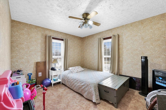 bedroom featuring multiple windows, ceiling fan, light colored carpet, and a textured ceiling