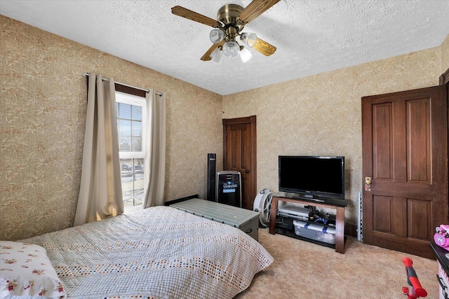 bedroom with light carpet, ceiling fan, and a textured ceiling