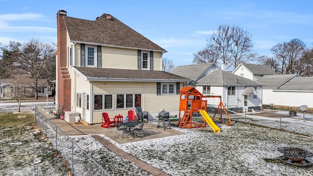 rear view of house with a fire pit, a patio, and a playground