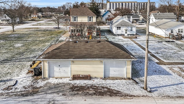 snow covered rear of property with a garage