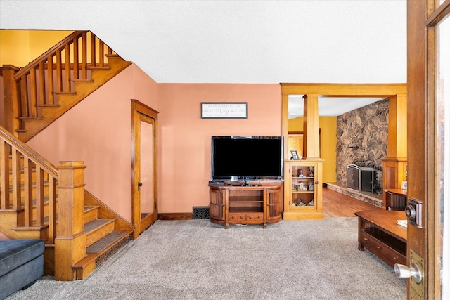 living room featuring a stone fireplace and carpet