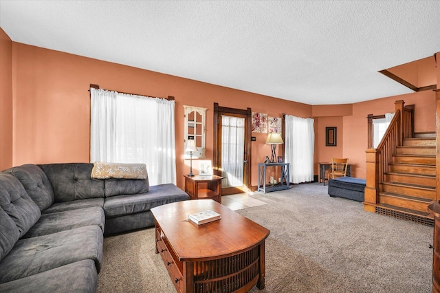 carpeted living room featuring a textured ceiling