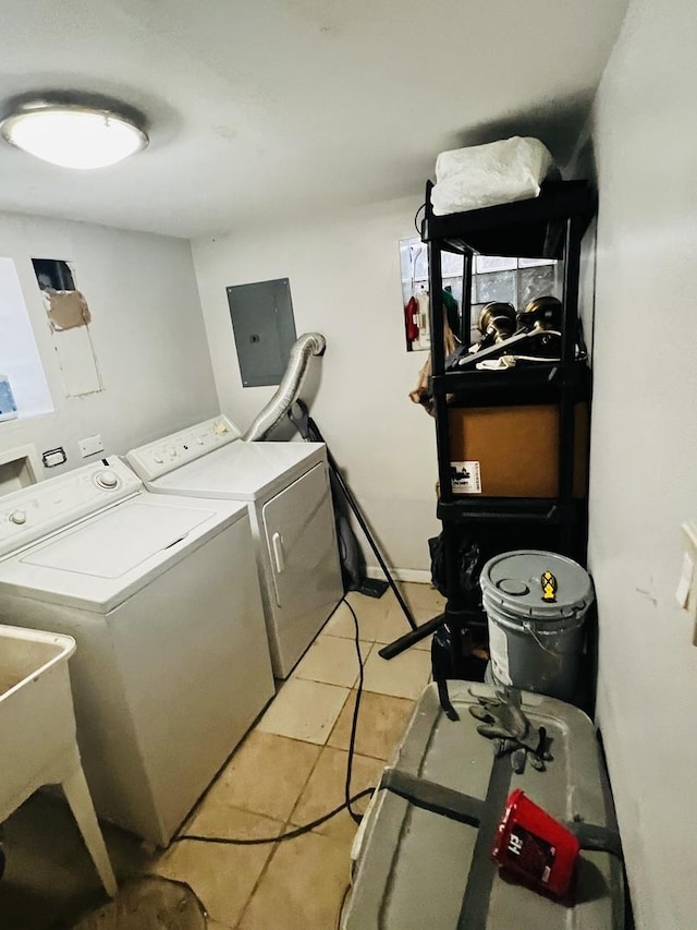 laundry area with sink, light tile patterned floors, washing machine and clothes dryer, and electric panel