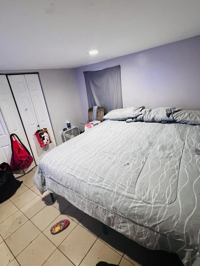 tiled bedroom with a closet