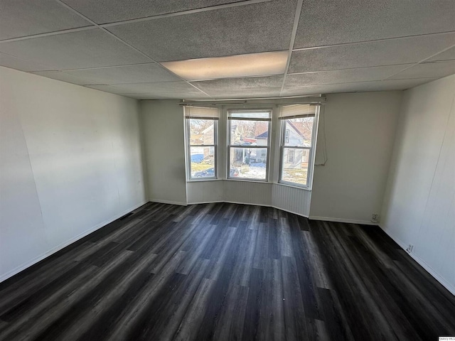 spare room with dark hardwood / wood-style floors and a paneled ceiling