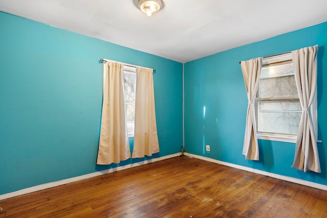 unfurnished room featuring hardwood / wood-style flooring and a healthy amount of sunlight