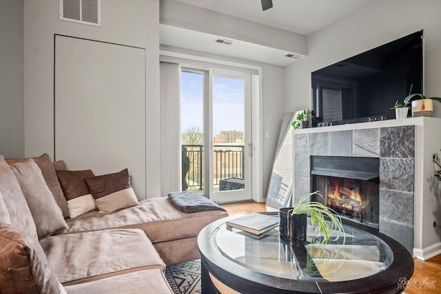 living room with hardwood / wood-style floors and a tile fireplace