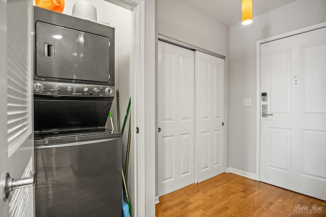 washroom featuring stacked washer and dryer and light hardwood / wood-style floors