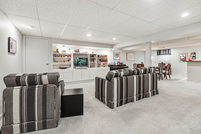 living room with a paneled ceiling and light colored carpet