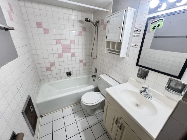 full bathroom featuring tile walls, tiled shower / bath combo, vanity, toilet, and tile patterned floors