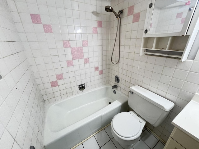 full bathroom with tiled shower / bath, tile walls, vanity, toilet, and tile patterned floors