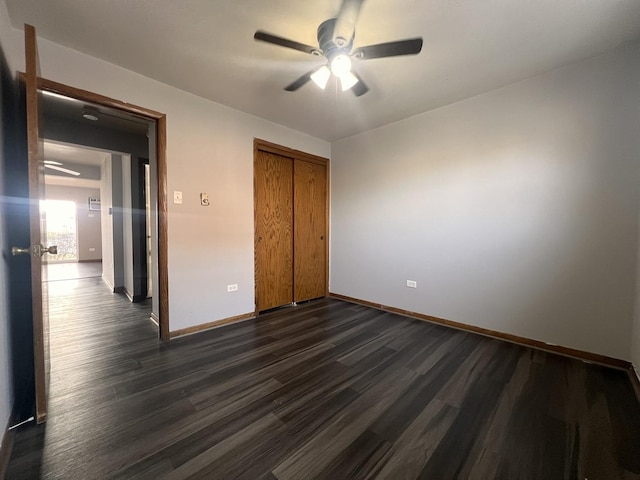 unfurnished bedroom featuring dark wood-type flooring, ceiling fan, and a closet