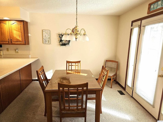 carpeted dining space with a textured ceiling and a notable chandelier