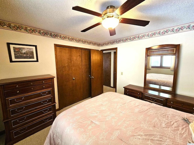 carpeted bedroom with ceiling fan, a textured ceiling, and a closet