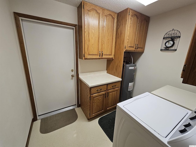 laundry area featuring washer and dryer, cabinets, electric water heater, and a textured ceiling