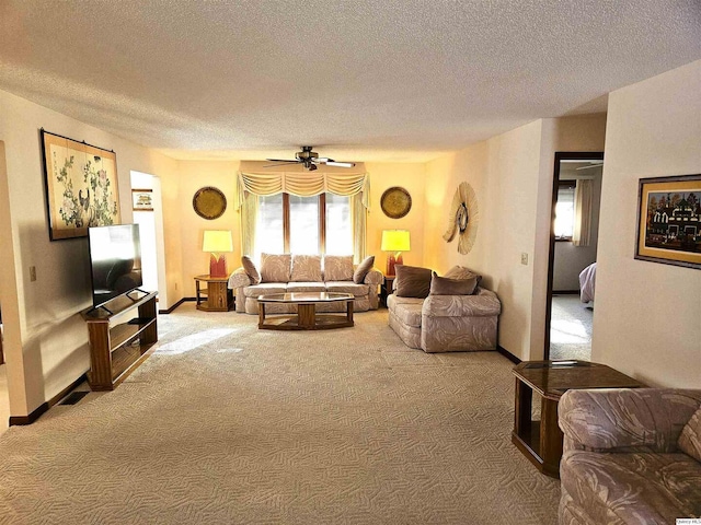 living room featuring ceiling fan, a textured ceiling, and carpet flooring